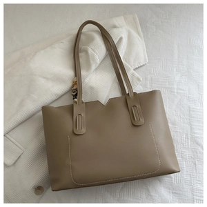 Macro shot of khaki matte tote bag with contrast stitching and decorative silk scarf