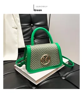 Detail of green leather handbag with herringbone fabric panel and golden M buckle