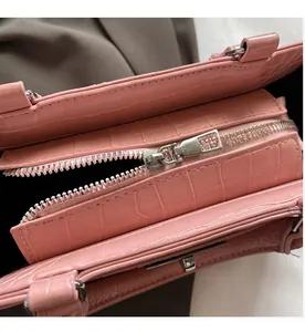 Close-up of pink crocodile texture leather with a smooth silver metal zipper detail
