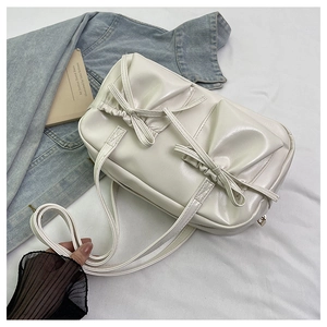 Detail of white glossy shoulder bag with bow accents and drawstring elements