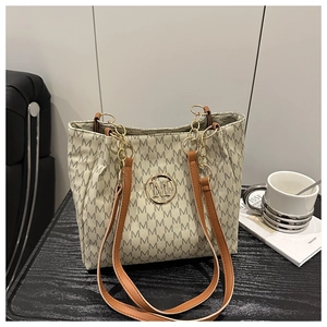 Detailed macro of beige monogram tote bag with gold chain and luxury leather strap