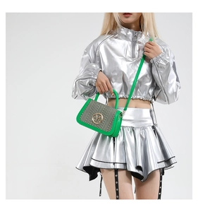 Model view of green trim herringbone mini bag with gold M logo and metallic outfit