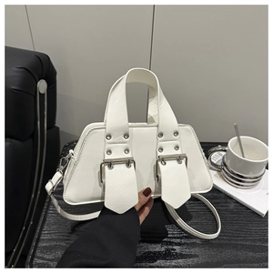 Detail der weißen Handtasche aus Lackleder in Trapezform mit silbernen Metallschnallen