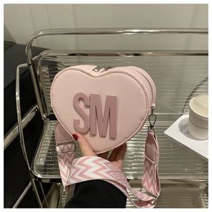 Pink heart-shaped crossbody bag with SM logo and wide patterned strap detail