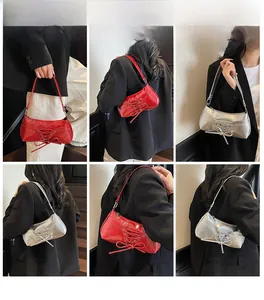 Close-up of minimalist ballet style underarm bag with bow decoration and shiny finish