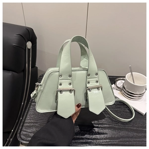 Detail der mintgrünen geometrischen Handtasche mit silbernen Ösenriemen und Metallbeschlägen