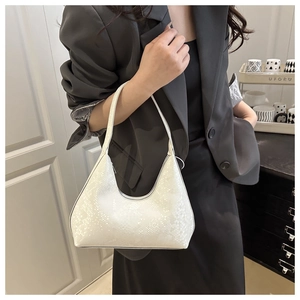 Detailed view of white faux-snakeskin crescent shoulder bag with zipper closure