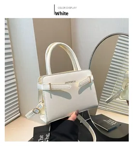 Détail du sac à main blanc en cuir avec fermoir doré et bandoulière réglable