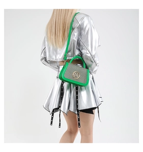 Detail of green leather shoulder bag with monochrome woven flap and metal M logo