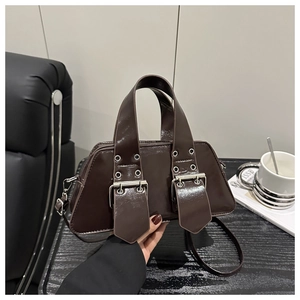 Detailansicht der glänzenden dunkelbraunen Lackleder-Handtasche mit zwei Schnallen und Silber