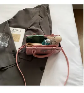 Internal capacity of pink crocodile pattern handbag showing phone, wallet and umbrella