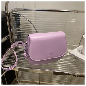 Détail du sac selle en cuir PU lilas montrant le lettrage de mode et la boucle métallique
