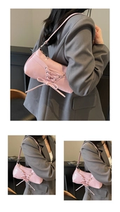 Detail of pink corset-style shoulder bag with criss-cross lace-up and ribbon accents