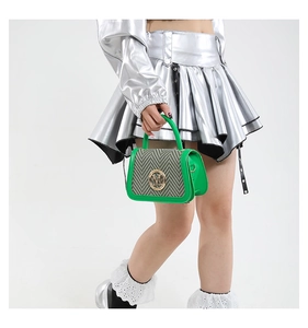 Detail of green woven mini handbag with metallic M letter buckle and leather handle