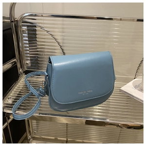 Détail du sac à main bandoulière bleu clair avec logo Fashion Trend 1996 sur support