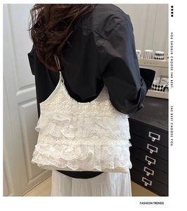 Detail of layered white lace pleats and delicate floral texture on the tote bag