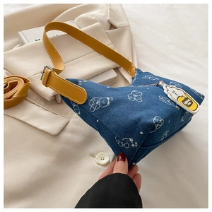 Close-up of blue denim underarm bag with white bear prints and a yellow leather strap