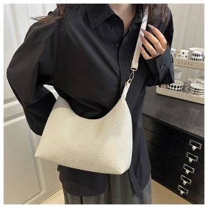 Détail du sac à bandoulière crème avec texture sergé et crochets métalliques dorés chic