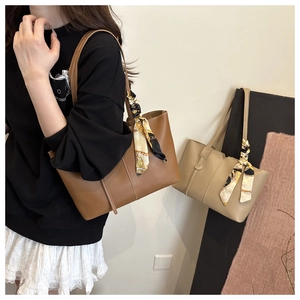 Detail of premium tote bags in brown and beige with stylish printed silk scarves on handles