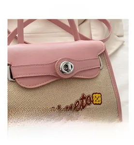 Close-up of pink leather trim and canvas texture with a silver rotary metal lock