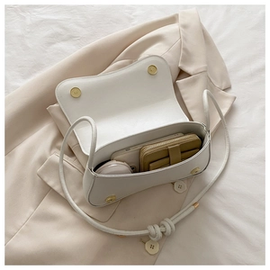 Detailed interior of white faux leather crossbody bag showing space for phone and wallet