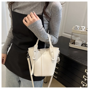 Detail of white lychee pattern bucket bag with silver metal hooks and detachable strap