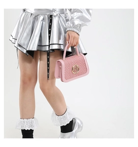 Detailed shot of pink crossbody box bag with red houndstooth weave and gold logo