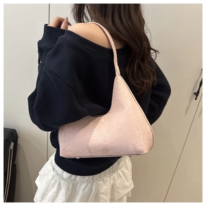 Pink textured hobo bag with scale pattern shown as a side shoulder view on a model