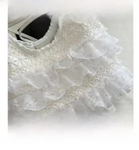 Close-up of white lace layers and quilted texture on a large vacation tote bag
