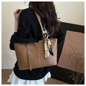 Brown leather tote bag with V-cut opening and decorative silk scarf detail