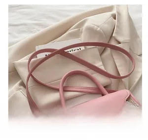 Detail of pink and beige leather crossbody bag with silver twist lock and adjustable strap