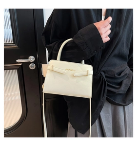 Détail du sac à main blanc en cuir avec bandoulière et inscription du logo doré