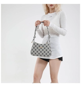 Dettaglio del motivo a quadri vintage e della zip in metallo sulla borsa grigia a spalla