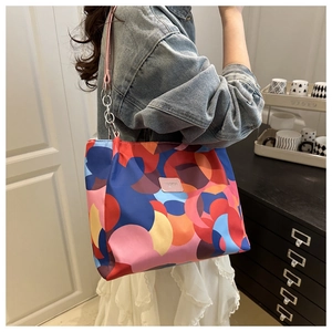Detail of colorful abstract print tote bag with pink leather SHIOPIN logo and metal chain