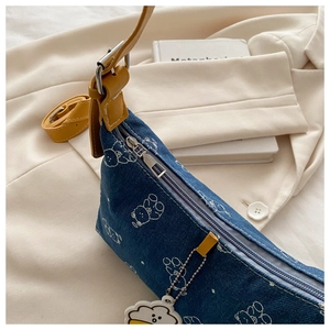 Detail of printed denim underarm bag with cute bear patterns and yellow leather strap