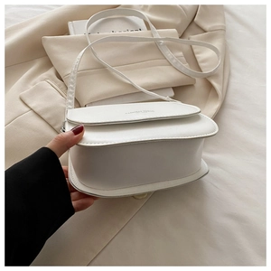 Détail d'un sac besace blanc minimaliste en similicuir avec logo Fashion Trend gravé
