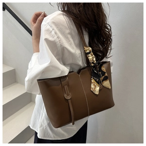 Brown vintage leather tote bag with silk scarf detail and contrast stitching on a model