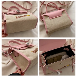 Detail view of contrast canvas bag with pink leather trim and timeto embroidery