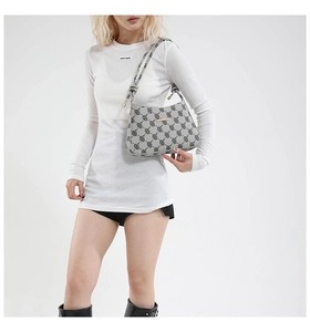 Dettaglio borsa hobo grigia a fantasia con logo dorato e tracolla con nodo