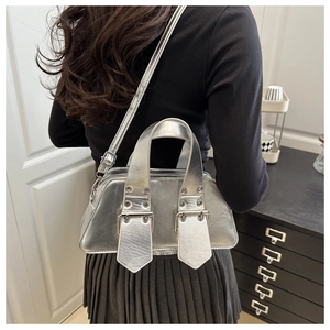 Silberne Metallic Boston Bag mit großen Ösen und breitem Gurt in Crossbody-Ansicht