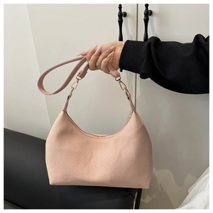 Close-up of pink tote bag with diagonal woven texture and gold metal hardware