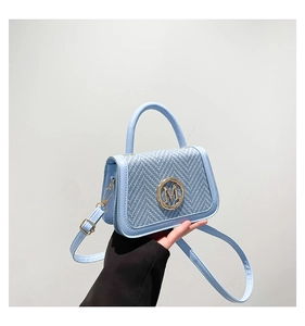 Detail of light blue box bag featuring tweed texture and gold M logo buckle