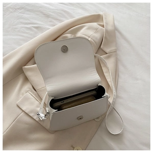 Detail view of white square bag interior showing phone and wallet storage space