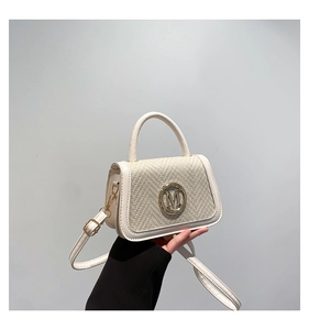 Detail of cream leather and woven mini handbag with golden M metal emblem and strap
