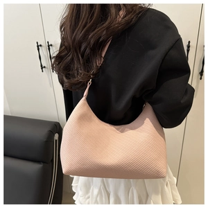 Detailed close-up of pink ribbed hobo bag showing texture and stylish shoulder strap