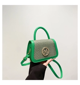 Detailed shot of green leather and gray herringbone stitching with golden M logo