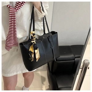 Detail of black tote bag with white contrast stitching and decorative silk scarf
