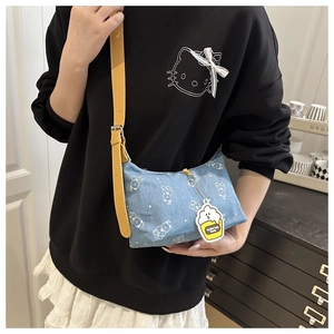 Detail of printed denim shoulder bag with white bear motifs and yellow leather strap