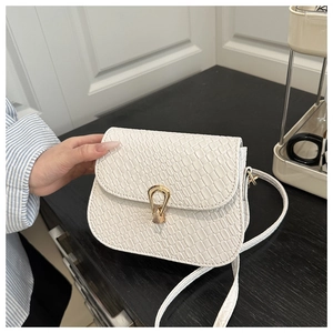Close-up of white embossed crocodile leather texture and golden teardrop metal clasp