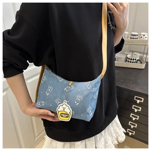 Detail of light blue denim crossbody bag with cartoon bear prints and yellow leather strap